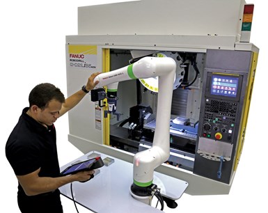 Man programs a cobot in front of a machine tool